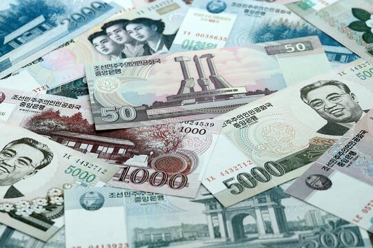 North Korean won money banknotes pile on table. North Korea bills of KPW currency close up