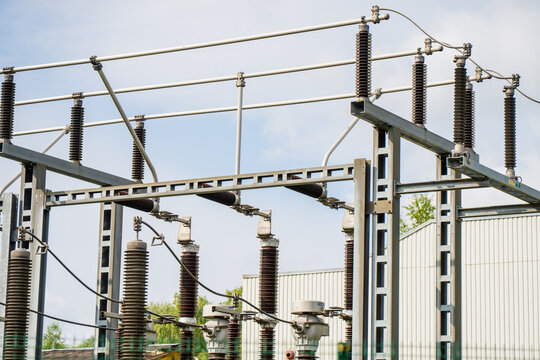 Electrical power transmission substation showing vertical porcelain insulators busbar conductors and structural steel support frames