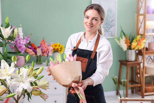 Florist with bouquet of beautiful lilies in shop