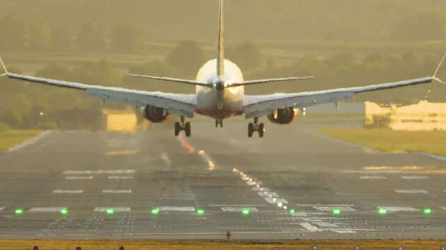 Passenger airplane landing on the runway at sunset