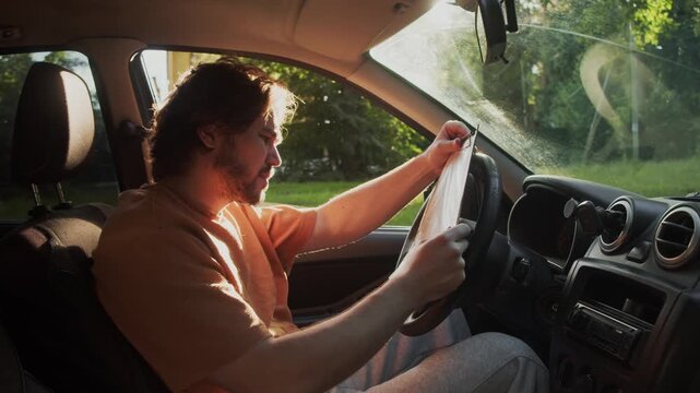 Disappointed driver reads insurance documents after a car accident and reacts with shock. He sits in the driver s seat, overwhelmed by the terms of the policy.