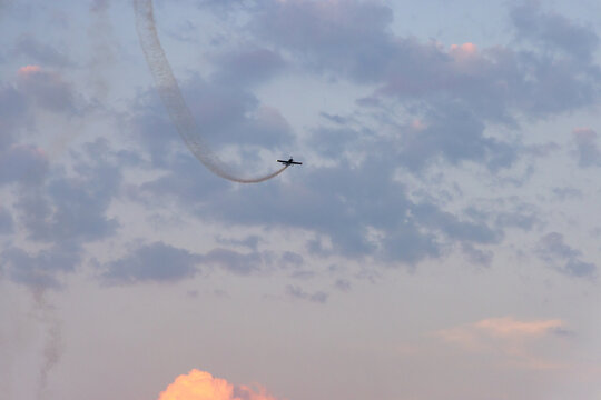 Aerobatic Air Show Plane Leaving Smoke Trail Over Cloudy Sky at Sunset in Chilliwack BC Canada