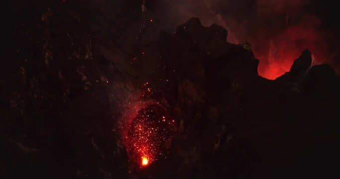 Volcano erupting at night. Mount Yasur with glowing lava, fire, and sparks flying into the dark sky from its active crater in Tanna, Vanuatu, showcasing natural volcanic power. Aerial view drone shot