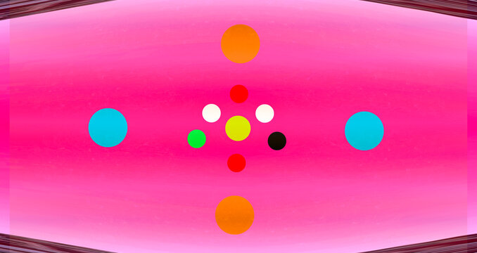 A lively constellation of shifting, colourful circles arranged in perfect symmetry, all set against a soft pink backdrop. The vibrant hues play off one another with a sense of motion and balance, 