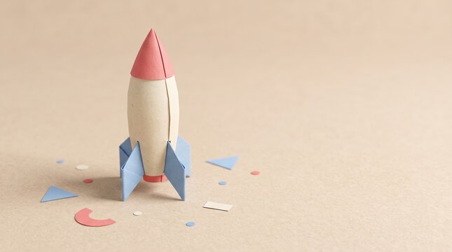 Handmade paper rocket standing on beige surface