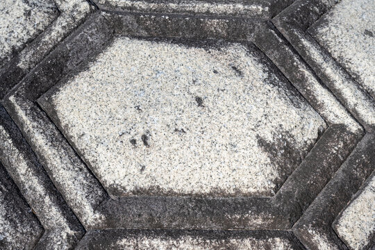 Hexagonal turtle shell pattern carved on granite stone base of traditional monument in South Korea.