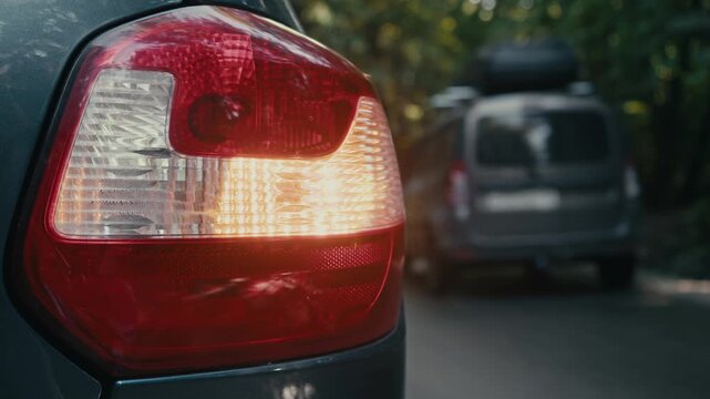 Car parked on roadside with hazard lights flashing during emergency situation. Passing vehicles drive by without stopping to provide assistance.