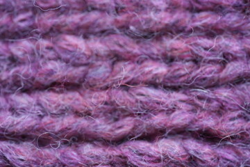Fototapeta premium Purple wool knit texture background Macro close-up of purple knitted wool fabric with soft fuzzy yarn and visible stitch pattern. Cozy warm textile texture in rich violet tones, ideal for fashion, win