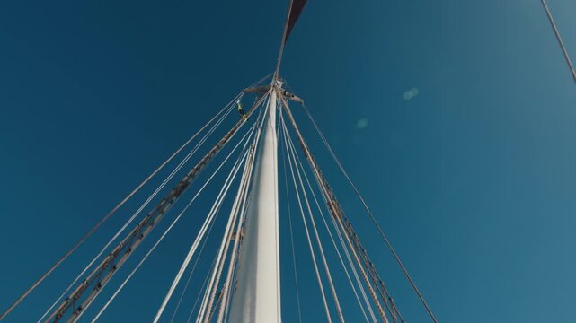 Crew work with the sails on the big expeditional sailing vessel moving in the Atlantic Ocean