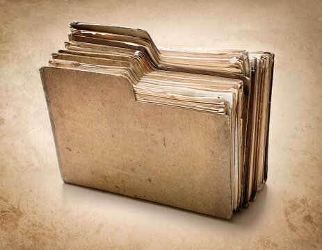 old paper folders stacked on a textured beige background