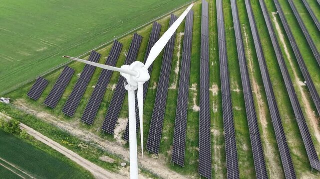 Ecological power station with solar panels and wind turbine in field