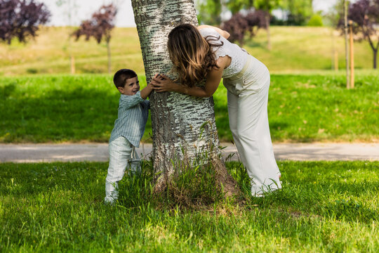 Mother and son playing hide and seek in park