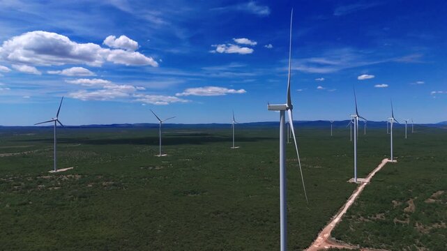 Aerial Drone View of Wind Turbines in a Green Landscape with Mountains
