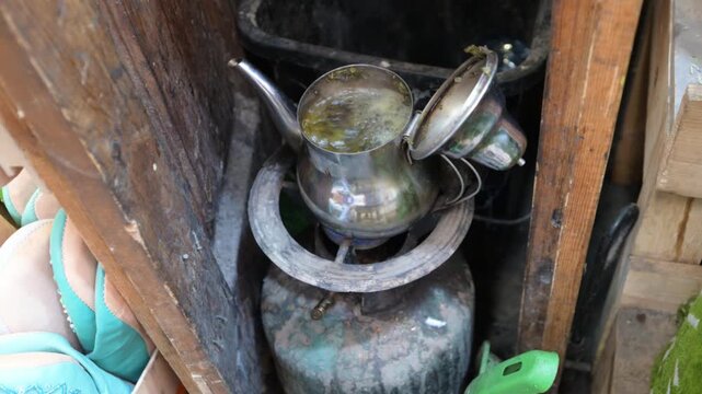 Marrakech, morocco. August 8, 2026. Moroccan mint tea brewing in a traditional metal teapot on a gas stove. Authentic street scene from the souk in the medina of marrakech