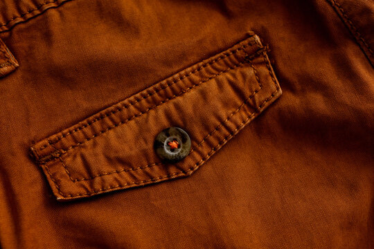 Brown cargo trouser flap pocket with button construction detail