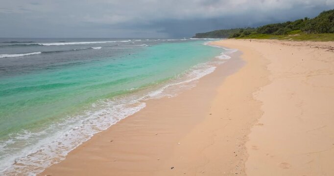 Port Resolution beach on Tanna Island, Vanuatu, presents a tropical coastline with white sand, clear turquoise water, and gentle ocean waves under a cloudy sky. Exotic travel, vacation destination