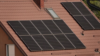 Fototapeta premium Zdjęcie przedstawia rzędy paneli fotowoltaicznych zamontowanych na dachu budynku. 