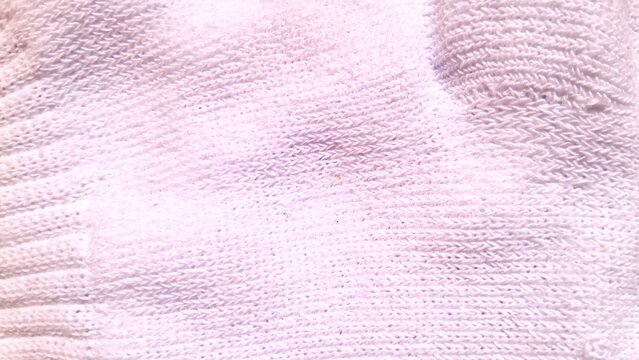 Soft white cotton fabric texture showing detailed knitted sweater weave patterns