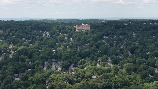 Slow lateral drone pan across wooded South Mountain neighborhoods in Essex County