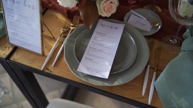 Sophisticated stationer y presentation featuring gold utensils and floral decor