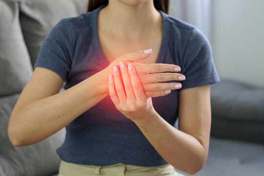 Carpal tunnel syndrome. Unrecognizable woman holding her painful hand suffering inflammation or injury.