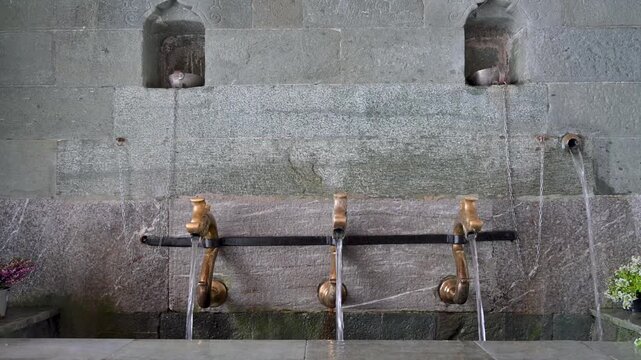 Water flowing from an old stone fountain