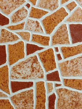 Natural mosaic of irregular stone tiles with earthy tones and contrasting white grout, creating rustic decorative surface appeal