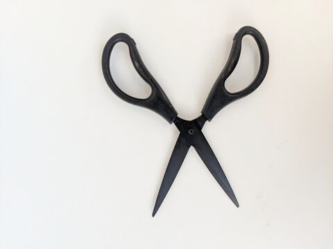 Black scissors isolated on white background highlighting simple household cutting tool.
