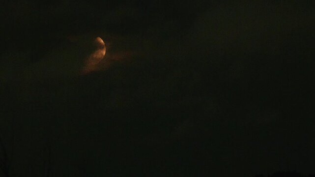 Tokyo,Japan - August 21, 2026: The half moon shining beyond thin clouds
