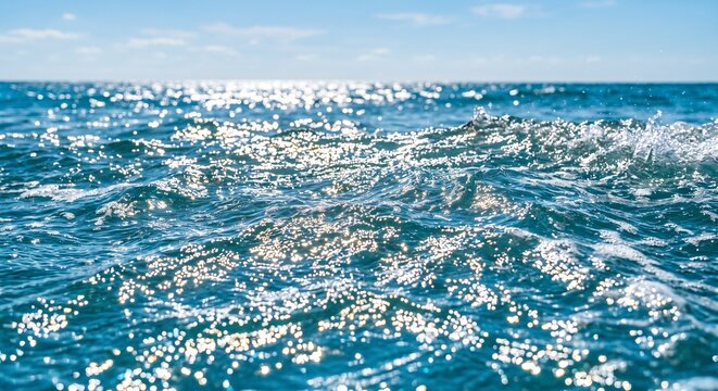 Close up of sparkling blue ocean waves reflecting bright sunlight