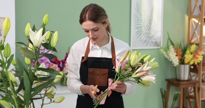 Florist trimming stems of lilies in shop