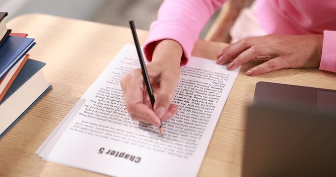 Writer working on her book at desk in office, closeup