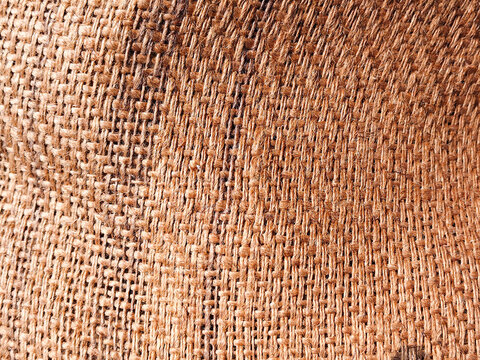 Burlap texture close-up with natural jute weave pattern, warm brown tones and rustic fiber detail
