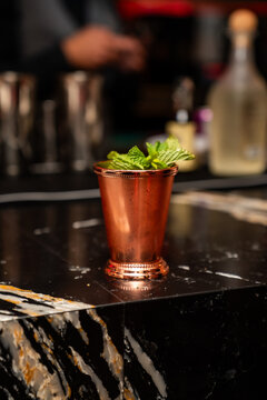 Classic mint julep cocktail in a rustic copper mug garnished with fresh mint leaves.