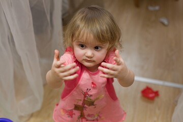 Fototapeta premium Toddler Girl Reaching Out Hands Indoors