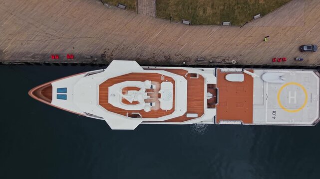 A stunning aerial view showcases the elegant La Datcha resting at the dock in Halifax, Nova Scotia. The city backdrop enhances the yacht's grandeur against the clear blue sky