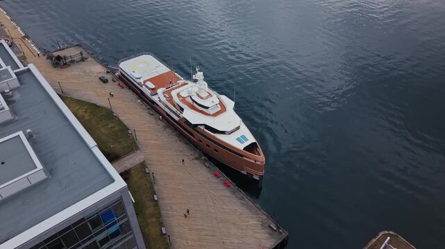 An aerial view captures the stunning luxury expedition yacht La Datcha at the bustling Halifax dock. The vibrant city surrounds this masterpiece, blending nature and luxury