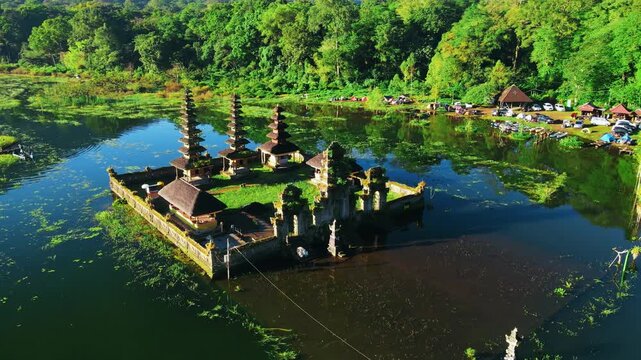 Scenic view of Gubug Temple at misty Lake Tamblingan surrounded by lush rainforest in Bedugul, Bali, Indonesia