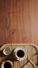 Fototapeta premium Overhead view of a cup of black coffee, pour-over dripper and small pitcher on a bamboo tray over warm wood. Artisan morning brew flat lay.