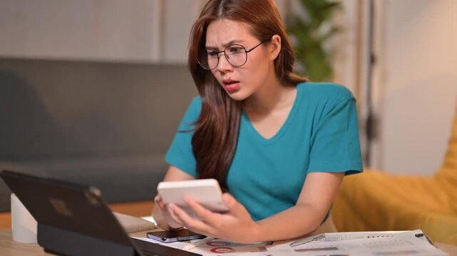 Stressed asian woman calculating finances at night