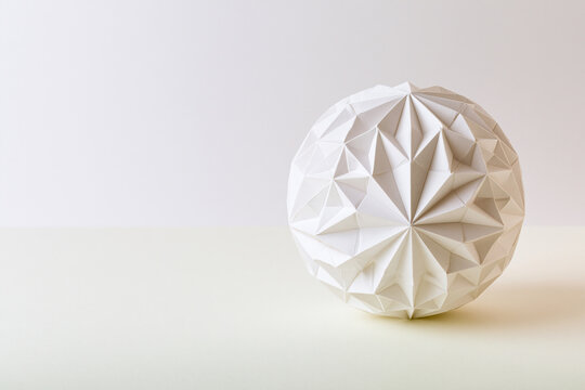Geometric origami ball with folded facets surreal geometry concept