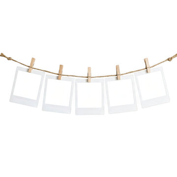 Five empty polaroid photo frames hanging on a rope with wooden clips
