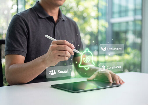ESG business strategy displayed on digital tablet screen held by professional person using stylus pen in modern office setting with bright natural light and bokeh