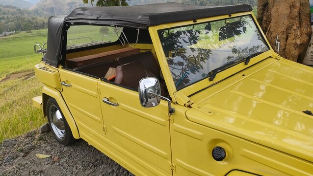 Yogyakarta, Indonesia, July 2, 2026; Bright yellow classic Volkswagen Type 181 Kurierwagen parked outdoors. Concept of retro automotive transport, vintage vehicle travel, and military style car photog