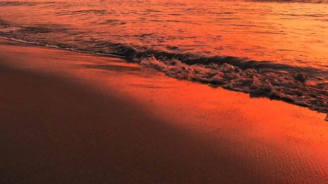 Slow motion 120fps of Gentle Wave Edge on Golden Sand during red sunset