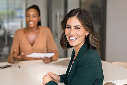 Portrait of confident businesswoman smiles at camera while attending job interview in modern office. Professionalism, positive communication between employer and candidate, career growth opportunities