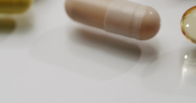 Different dietary supplements including vitamin C, Omega 3, D3, B12, and other mineral pills lying on a white background. Extreme macro view of various nutritional tablets, capsules, and softgels