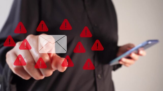 A businesswoman holding a smartphone while pointing at an animation of an email envelope surrounded by warning signs. Attention to spam email.