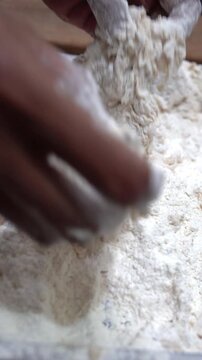Vertical extreme close up of thick shaggy flour breading on raw chicken for crispy fried chicken