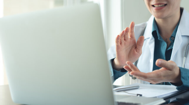 Female doctor using laptop for patient's online consultation or web conference, telemedicine concept